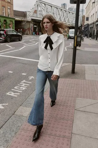 Блуза с воланами и контрастным бантом