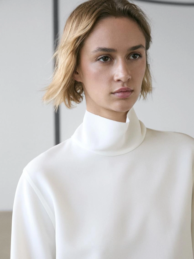 Блузка с высоким воротником и деталями на подоле