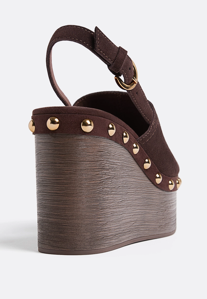 Кожаные босоножки на танкетке с заклепками