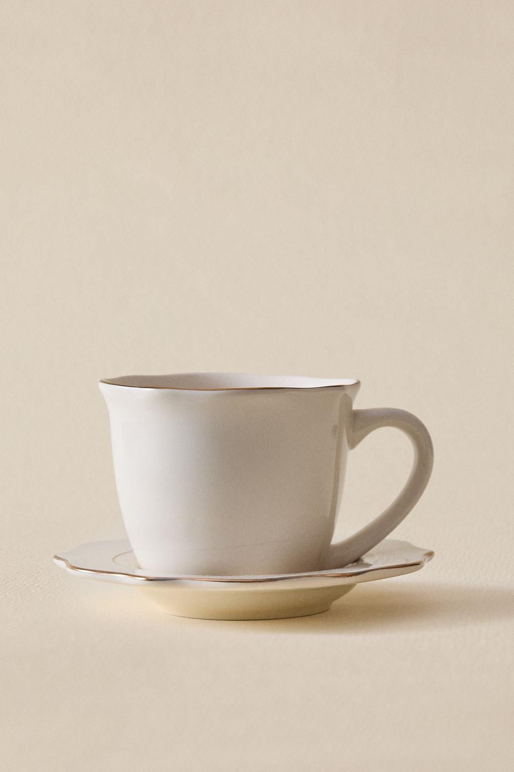 Фарфоровая чашка и блюдце с деталями на краю