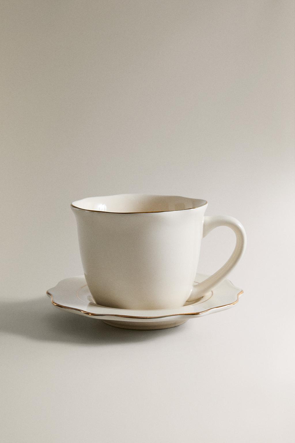 Фарфоровая чашка и блюдце с деталями на краю