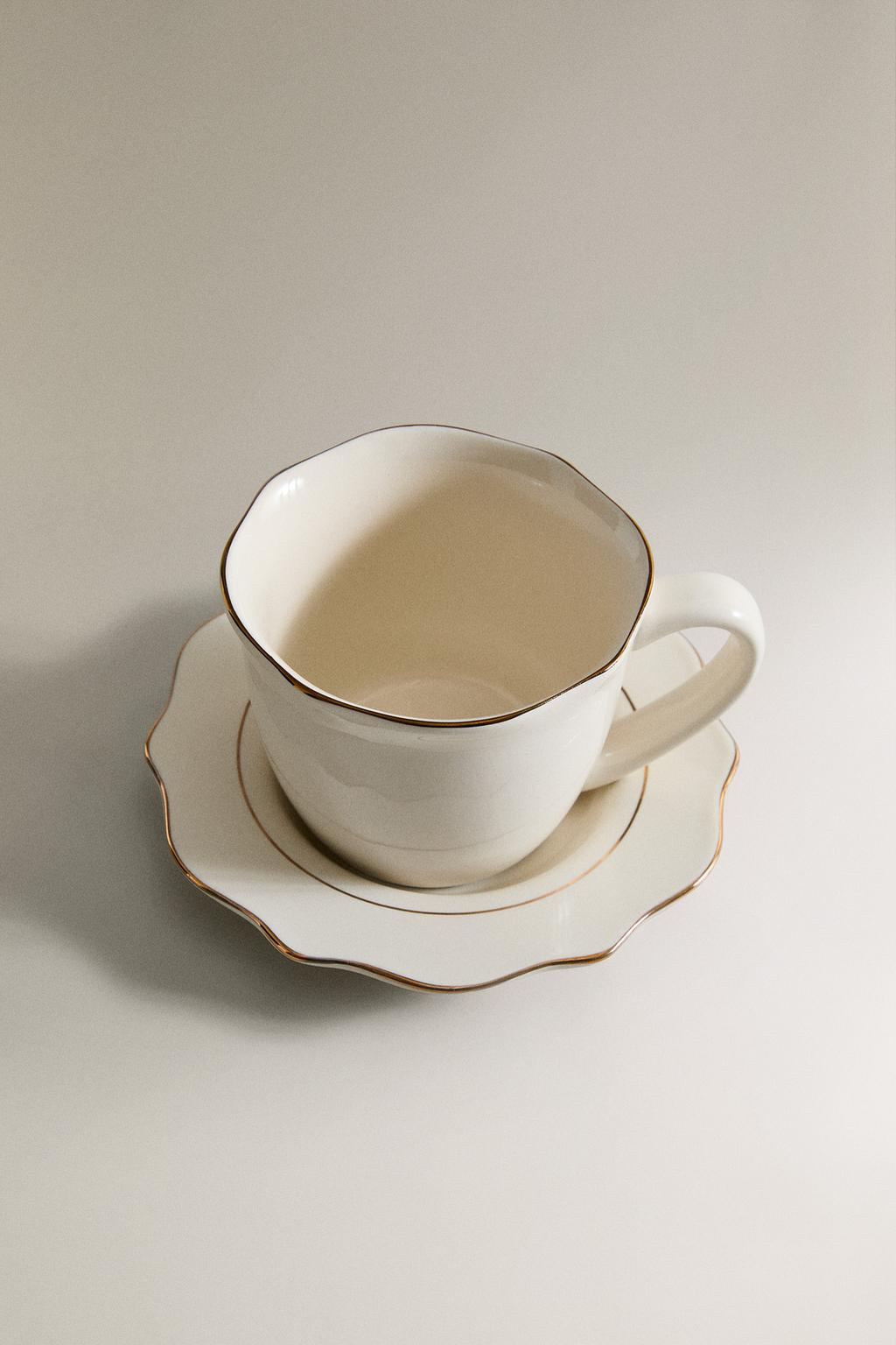 Фарфоровая чашка и блюдце с деталями на краю