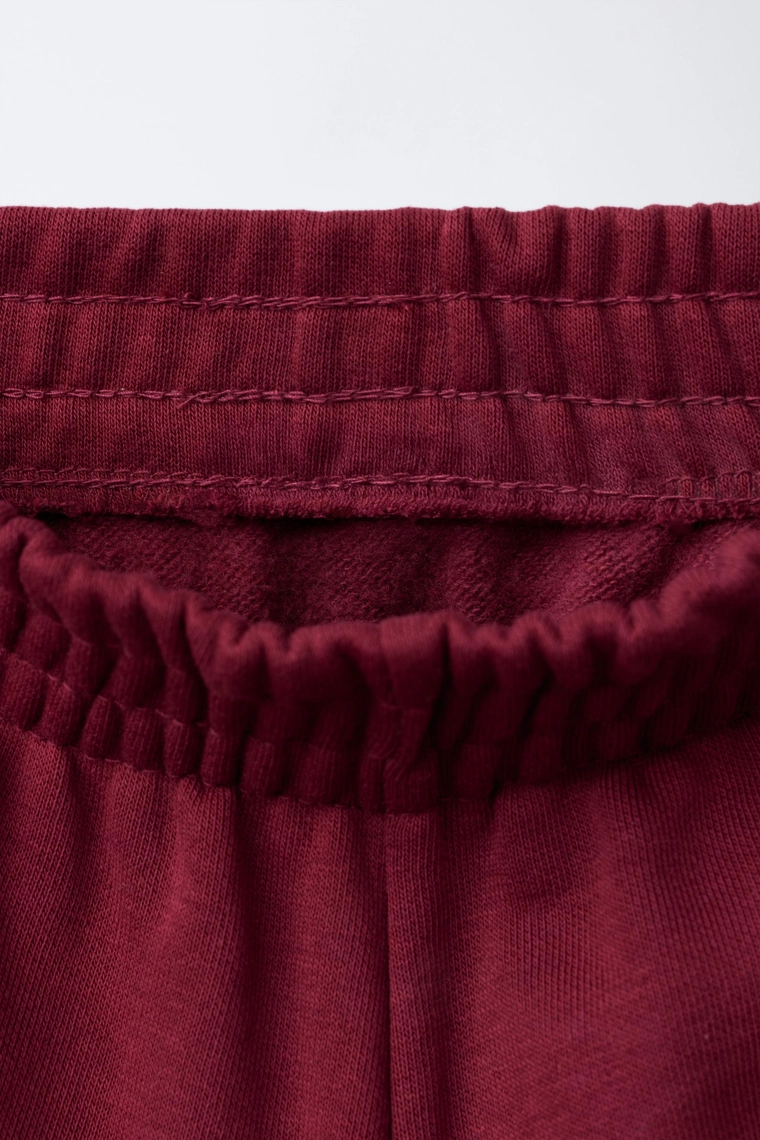 БРЮКИ-ДЖОГГЕРЫ ИЗ МЯГКОЙ ТКАНИ С ТЕКСТОМ