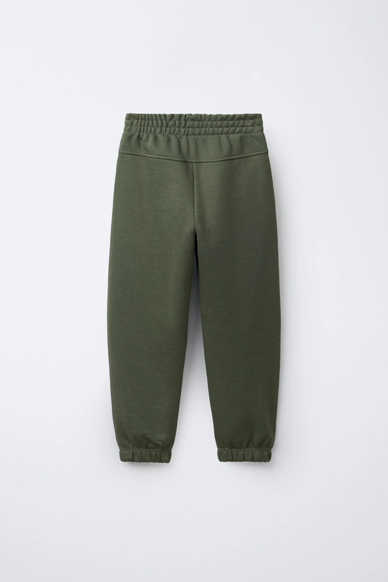 БРЮКИ-ДЖОГГЕРЫ ИЗ МЯГКОЙ ТКАНИ С НАДПИСЬЮ