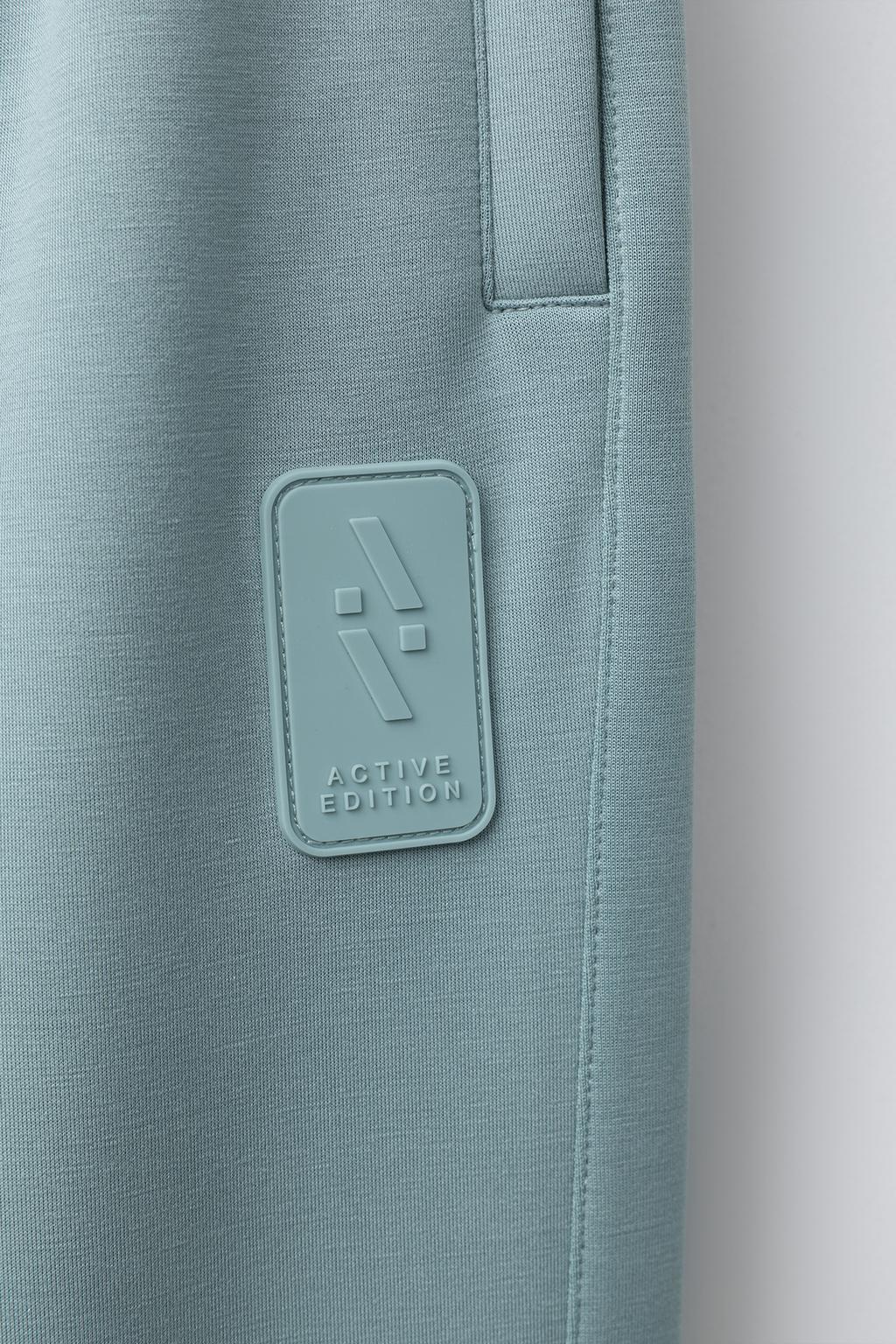 СПОРТИВНЫЕ БРЮКИ-ДЖОГГЕРЫ С ПРОРЕЗИНЕННОЙ НАШИВКОЙ