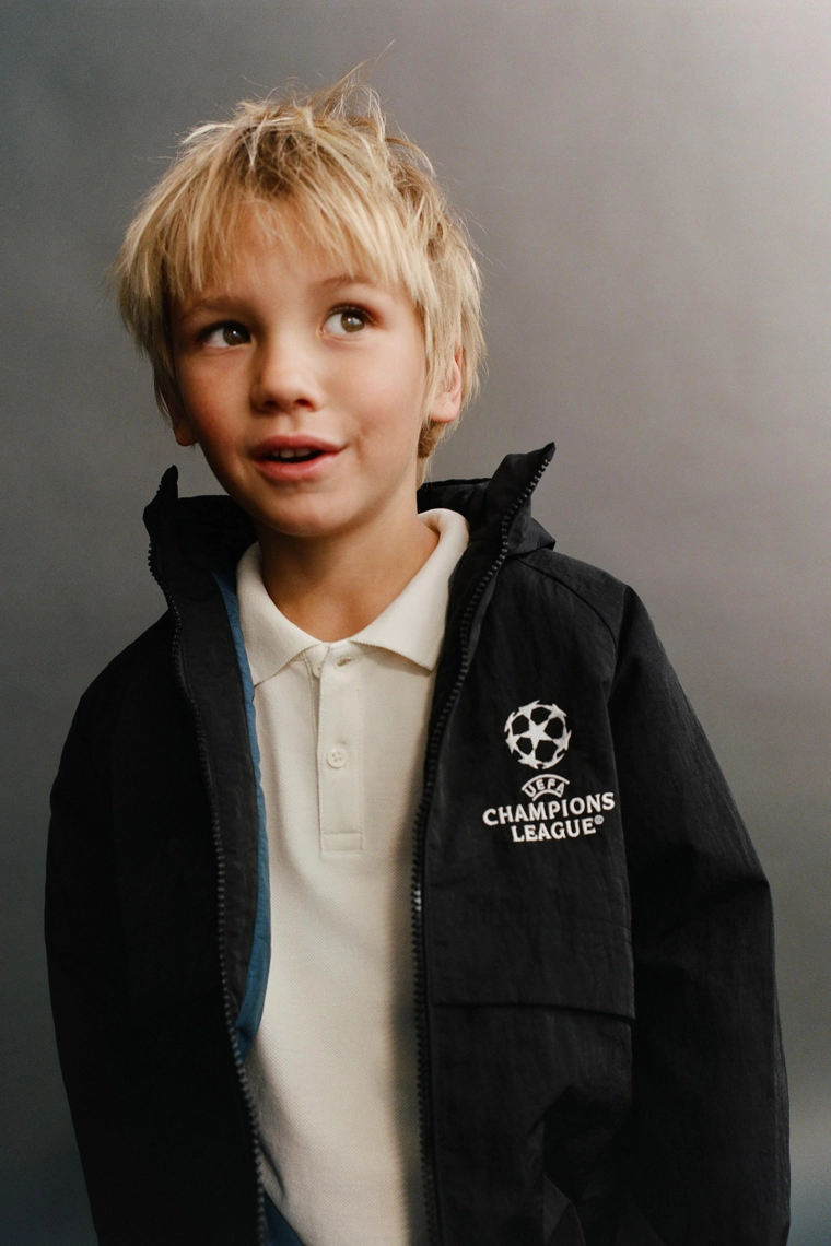 КУРТКА С ПОТАЙНЫМ КАПЮШОНОМ WATER REPELLENT UEFA CHAMPIONS LEAGUE ®
