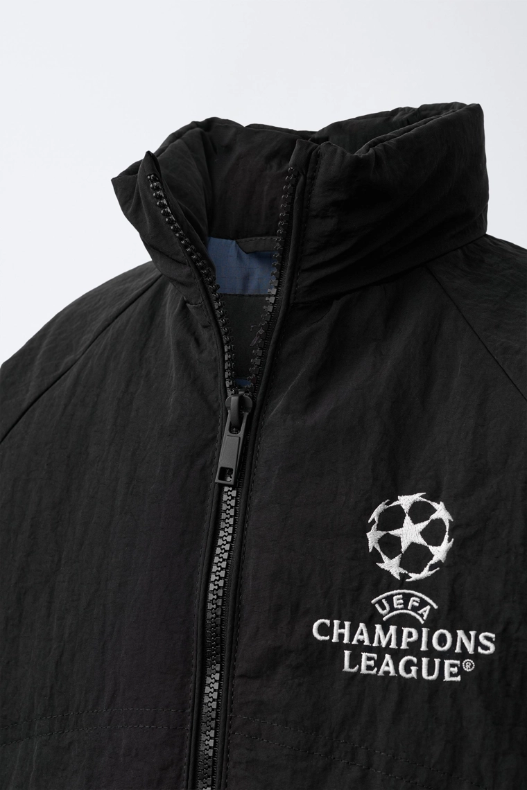 КУРТКА С ПОТАЙНЫМ КАПЮШОНОМ WATER REPELLENT UEFA CHAMPIONS LEAGUE ®