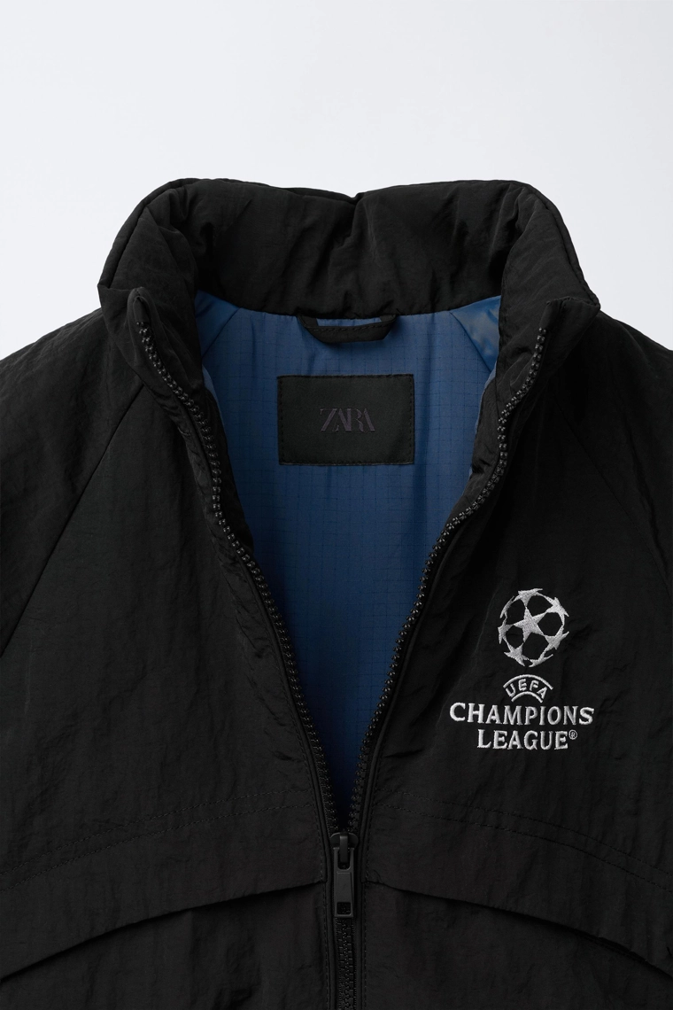 КУРТКА С ПОТАЙНЫМ КАПЮШОНОМ WATER REPELLENT UEFA CHAMPIONS LEAGUE ®